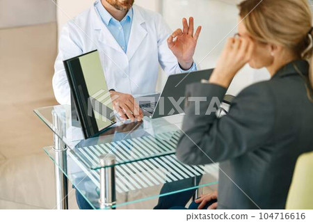 Woman looks in the mirror trying to choose glasses on the advice of an ophthalmologist 104716616