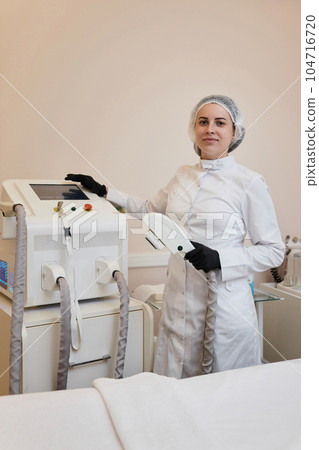 cosmetologist with laser, hair removal with modern equipment cosmetologist with laser, hair removal with modern equipment 104716720