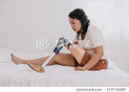 disability woman using prosthetics bionic leg touching new technology artificial leg hydraulic mechanical on bed at home disability woman using prosthetics bionic leg touching new technology artificial leg hydraulic mechanical on bed at home 104716986