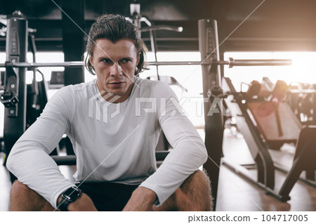 serious sport athlete man fitness trainer sitting in sport club gym body muscle training people 104717005