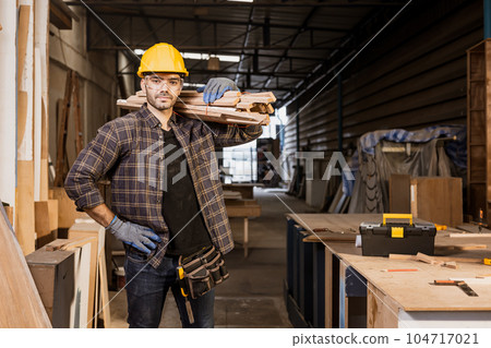 portrait hispanic indian male wood worker labor employee staff standing carrying pile of wood happy smile enjoy with job. portrait hispanic indian male wood worker labor employee staff standing carrying pile of wood happy smile enjoy with job. 104717021