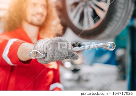 Happy mechanic worker tire service running schedule check automotive car in garage, auto tyre replace concept. 104717026