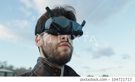 Man pilot a drone with technologic virtual reality glasses and remote controller 104721717