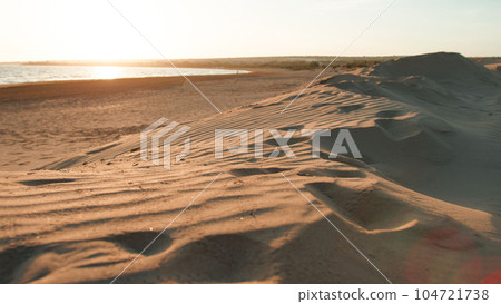 Fine sand dunes next to sea water Fine sand dunes next to sea water 104721738