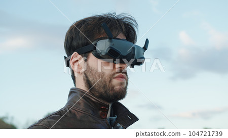 Man pilot a drone with technologic virtual reality glasses and remote controller Man pilot a drone with technologic virtual reality glasses and remote controller 104721739