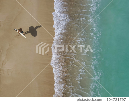 Aerial view of surfer at the beach 104721797