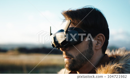 Man is wearing his vr glasses to drive his drone in fpv Man is wearing his vr glasses to drive his drone in fpv 104721982