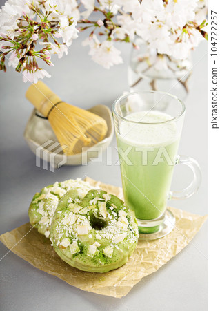 Matcha and white chocolate donuts with tea Matcha and white chocolate donuts with tea 104722257