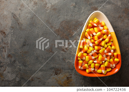 Candy corn in a bowl Halloween background 104722436