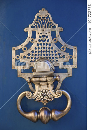 Knocker on a blue wooden door 104722788
