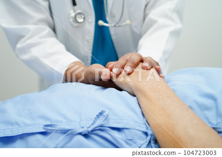Doctor holding hands Asian elderly woman patient, help and care in hospital. 104723003