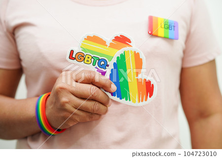 Asian woman with rainbow flag, LGBT symbol rights and gender equality, LGBT Pride Month in June. Asian woman with rainbow flag, LGBT symbol rights and gender equality, LGBT Pride Month in June. 104723010