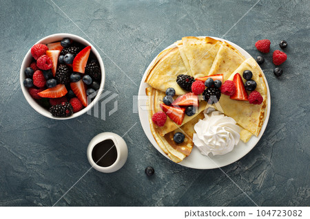 Thin crepes with whipped cream and berries Thin crepes with whipped cream and berries 104723082