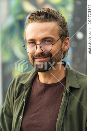 Handsome individual wearing glasses, situated outdoors against a graffiti-covered background. With a stylish and confident appearance, the subject exudes a modern and trendy vibe. . High quality photo Handsome individual wearing glasses, situated outdoors against a graffiti-covered background. With a stylish and confident appearance, the subject exudes a modern and trendy vibe. . High quality photo 104723543