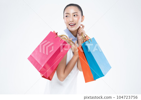 Beautiful Attractive Asian Woman smile and holding shopping bags feeling so happiness and enjoy with black Friday sale in Shopping mall,isolated on white background. Shopping Lifestyle Concept Beautiful Attractive Asian Woman smile and holding shopping bags feeling so happiness and enjoy with black Friday sale in Shopping mall,isolated on white background. Shopping Lifestyle Concept 104723756