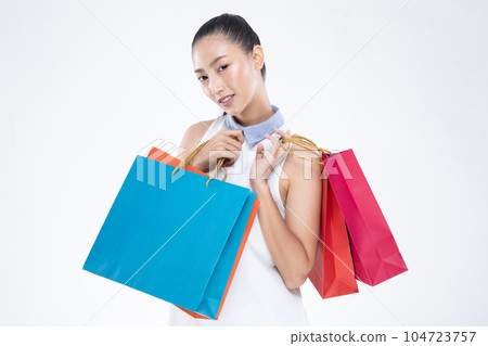 Beautiful Attractive Asian Woman smile and holding shopping bags feeling so happiness and enjoy with black Friday sale in Shopping mall,isolated on white background. Shopping Lifestyle Concept Beautiful Attractive Asian Woman smile and holding shopping bags feeling so happiness and enjoy with black Friday sale in Shopping mall,isolated on white background. Shopping Lifestyle Concept 104723757