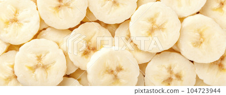 Background of ripe sliced yellow healthy banana slices, closeup. Food organic natural backdrop from fruit Background of ripe sliced yellow healthy banana slices, closeup. Food organic natural backdrop from fruit 104723944