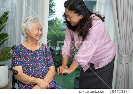 Caregiver help Asian senior woman on wheelchair with love at home. 104725584