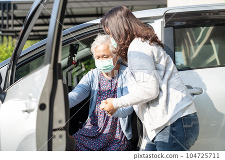 Caregiver help and support asian elderly woman sitting on wheelchair prepare get to her car to travel in holiday. Caregiver help and support asian elderly woman sitting on wheelchair prepare get to her car to travel in holiday. 104725711