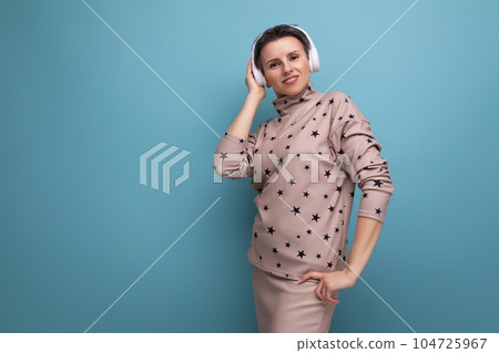 well-groomed young european lady with short streaked gray hair dances to music from headphones 104725967