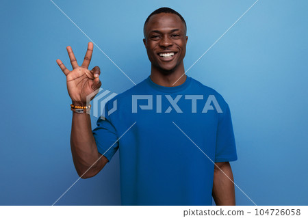 young friendly american man in a t-shirt on a blue background with copy space. people lifesal 104726058