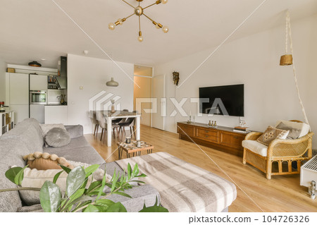 a living room with couches and a television on the wall in front of the sofa is wooden flooring a living room with couches and a television on the wall in front of the sofa is wooden flooring 104726326
