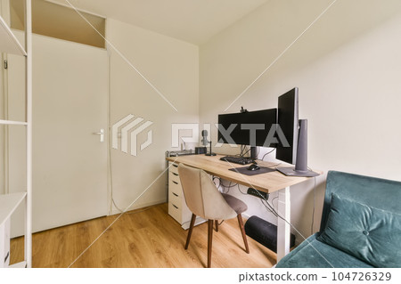 a small room with a desk, chair and computer monitor on the wall behind it is a white door that leads to a closet a small room with a desk, chair and computer monitor on the wall behind it is a white door that leads to a closet 104726329