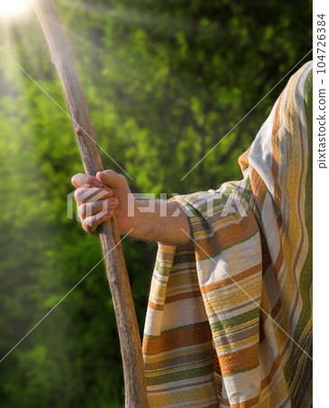 Man's hand with a wooden staff Man's hand with a wooden staff 104726384