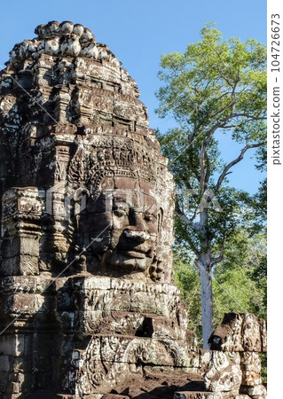 View of stone human faces, a notable feature on the towers of Khmer Bayon Temple. 104726673