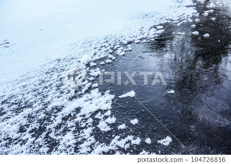 Ice on frozen pond, crystalline snow on top Ice on frozen pond, crystalline snow on top 104726836