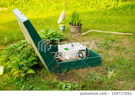 Private drainage systems. water sewer system. The green tin case is open for cleaning and maintenance on a sunny summer day Private drainage systems. water sewer system. The green tin case is open for cleaning and maintenance on a sunny summer day 104727091