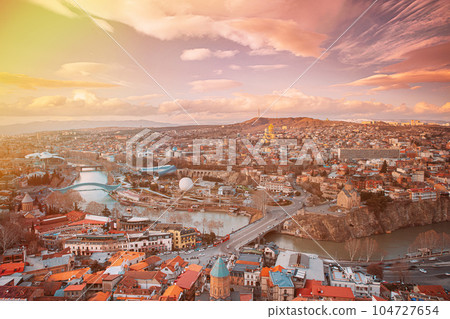 Tbilisi, Georgia. Top View Of Famous Landmarks In spring sunset Evening. Georgian Capital Skyline Cityscape. Justice House, Bridge Of Peace, Concert Hall, Rike Park And Presidential Palace, Metekhi. Tbilisi, Georgia. Top View Of Famous Landmarks In spring sunset Evening. Georgian Capital Skyline Cityscape. Justice House, Bridge Of Peace, Concert Hall, Rike Park And Presidential Palace, Metekhi. 104727654
