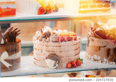 cake with strawberries, yummy assortment baked pastry in bakery. Various Different Types Of Sweet Cakes In Pastry Shop Glass Display. Good Assortment Of Confectionery. buffet with many desserts 104727656