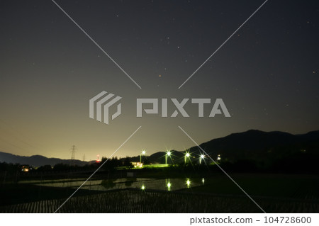 夜幕降臨，北斗市竹川町，舞鶴橋上空升起紅星心宿二。戶外的燈光倒映在稻田裡 104728600