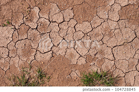 Texture of red dried cracked clay. Macro background image of dried clay 104728845