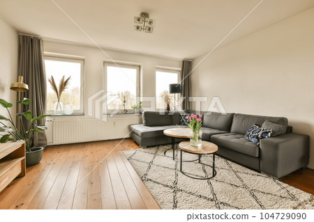a living room with a couch and coffee table in front of the window looking out to the cityscape 104729090