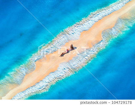 Aerial view of the beautiful young lying woman on the sandy beach Aerial view of the beautiful young lying woman on the sandy beach 104729178