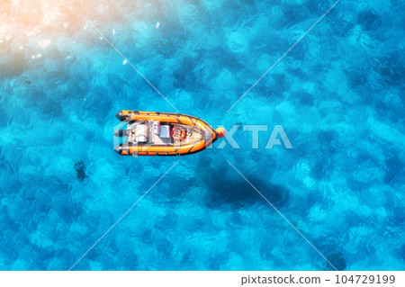Aerial view of beautiful orange boat in blue sea at sunset Aerial view of beautiful orange boat in blue sea at sunset 104729199