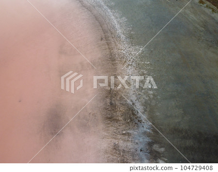 A bird's eye view of a red salt lake and black earth, captured by a drone. A bird's eye view of a red salt lake and black earth, captured by a drone. 104729408