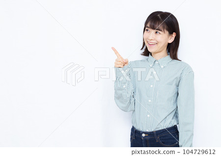 A woman in her thirties who raises her index finger in front of a white background A woman in her thirties who raises her index finger in front of a white background 104729612