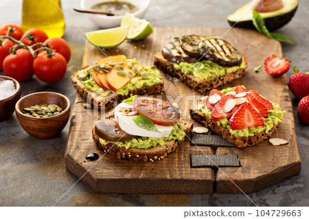 Variety of avocado toasts on a cutting board Variety of avocado toasts on a cutting board 104729663