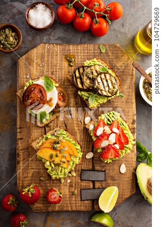 Variety of avocado toasts on a cutting board 104729669
