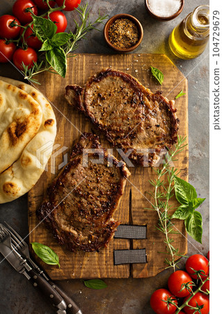Grilled ribeye steaks on a wooden board 104729679