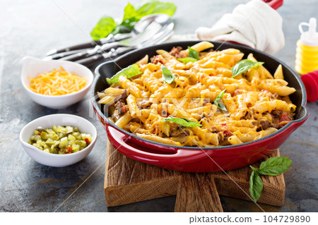 Cheesy pasta bake with ground beef and herbs 104729890