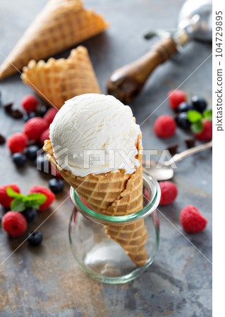 Vanilla ice cream scoop in a waffle cone 104729895