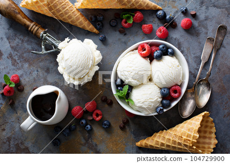Vanilla ice cream scoops in a bowl with fresh berries Vanilla ice cream scoops in a bowl with fresh berries 104729900