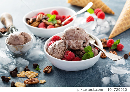 Chocolate ice cream with fresh berries in bowls Chocolate ice cream with fresh berries in bowls 104729910