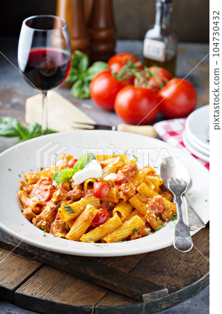 Rigatoni bolognese with fresh mozarella and basil 104730432