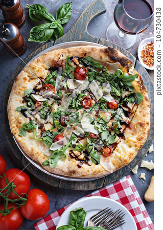 Pizza with arugula, tomato and parmesan Pizza with arugula, tomato and parmesan 104730438