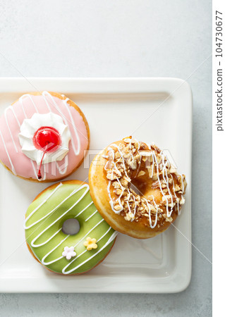 Assorted glazed fried donuts on a plate Assorted glazed fried donuts on a plate 104730677